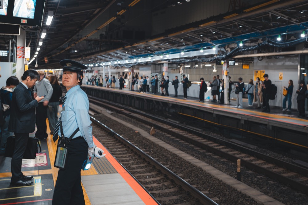Bahnbeamter auf einem Bahnsteig in Tokyo